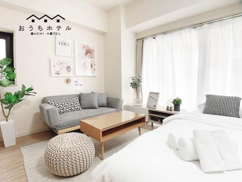 a living room with two beds and a couch at OUCHI HOTEL Takaramachi in Hiroshima
