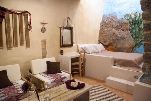 a room with two beds and a chair and a mirror at Sitanos Athena House in Sítanos