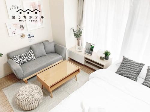 a living room with a couch and a coffee table at OUCHI HOTEL Takaramachi in Hiroshima