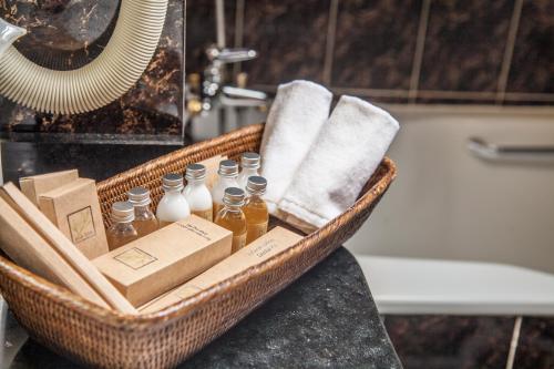 a basket with bottles and towels on a counter in a bathroom at Ali Hotel in Khabarovsk