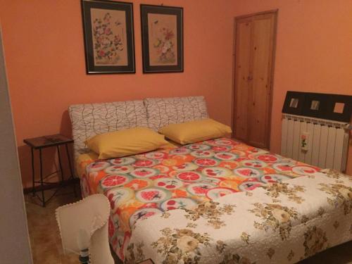 a bedroom with a bed with a colorful comforter at Agriturismo Cailuca in Pietralunga