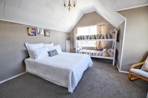 Un dormitorio con una gran cama blanca y una ventana en 2mins to lakefront Family Retreat, en Taupo