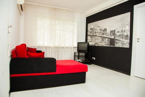 a living room with a red couch and a television at 2Rooms Semi-luxury Apartment on Pochtovaya 167-A Street in Zaporozhye