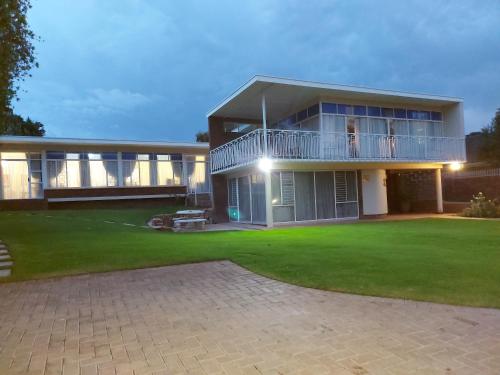 a large house with a lawn in front of it at Goedgedacht Guestrooms in Potchefstroom