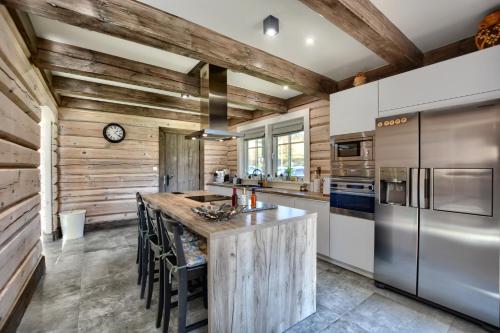 a kitchen with wooden walls and stainless steel appliances at CHATA POD PRZEHYBĄ in Stary Sącz