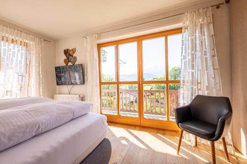 Un dormitorio con una cama y una silla y una ventana. en Ferienhaus „Adlerhorst“ eignet sich ideal für die ganze Familie, en Garmisch-Partenkirchen