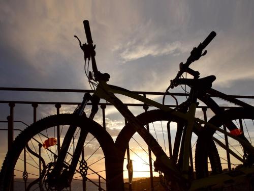 a bike parked against a fence with the sunset in the background at Villa Kamen Green in Vela Luka