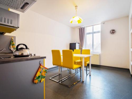 a kitchen with a table and yellow chairs at Elemels Planet in Ustroń
