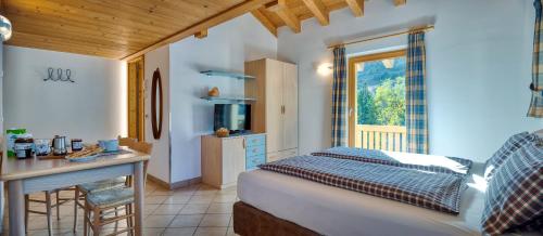 sypialnia z łóżkiem, stołem i oknem w obiekcie Chalet Italo (Gesa) w Livigno