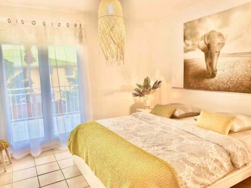 a bedroom with a bed and a painting of an elephant at Villa Magellan, walkable Orient Bay beach, private pool in Orient Bay