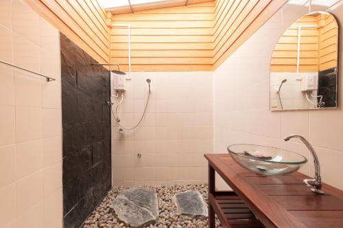 a bathroom with a sink and a shower at บ้านสวนวารินทร์ รีสอร์ท in Pak Chong