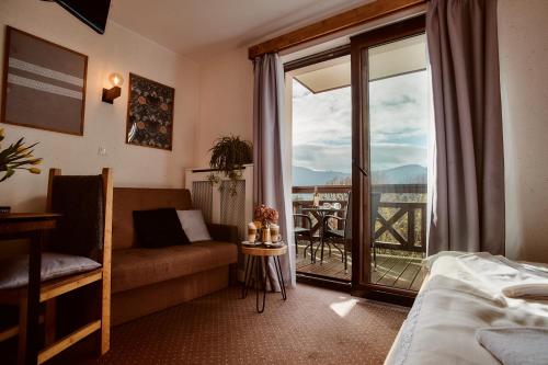 Cette chambre d'hôtel comprend un lit et un balcon. dans l'établissement Perła Beskidu, à Ustroń
