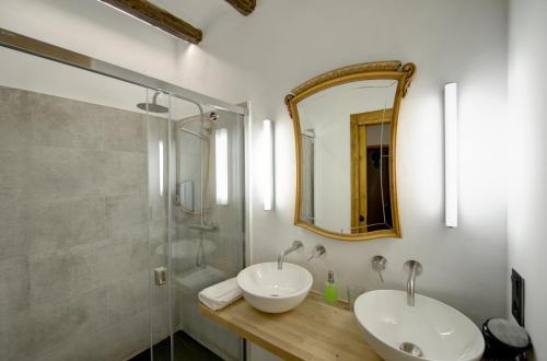 a bathroom with two sinks and a shower and a mirror at Lo Palauet de la Muralla in Balaguer