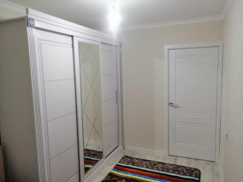 a walk in closet with two white doors and a rug at Уют в Авангарде in Atyraū