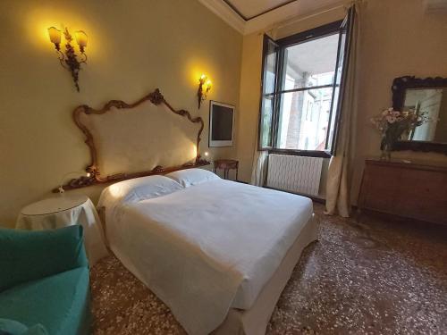 1 dormitorio con 1 cama blanca grande en una habitación en A PRIVATE TERRACE IN THE HEART OF VENICE, en Venecia
