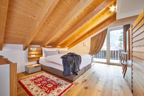 1 dormitorio con cama y ventana grande en Bader Suites en Garmisch-Partenkirchen