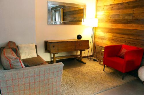 Una sala de estar con un sofá, una mesa y una silla. en Madame Vacances Chalet Acajuma, en Le Joseray