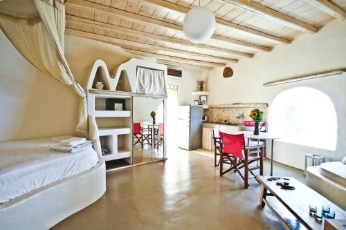 a room with a bed and a kitchen with a table at Castle Panigirakis in Mýkonos City