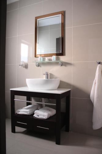 a bathroom with a sink and a mirror and towels at A-Z Boutique Guesthouse in Windhoek