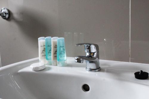 a bathroom sink with two bottles of toothbrushes on it at A-Z Boutique Guesthouse in Windhoek