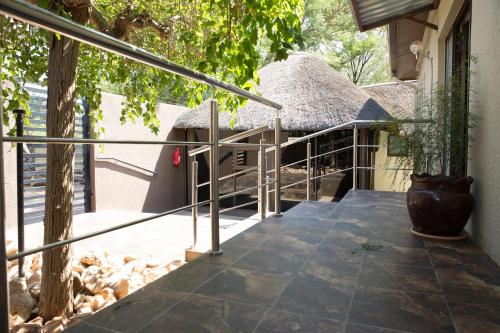 uma varanda de uma casa com telhado de palha em A-Z Boutique Guesthouse em Windhoek