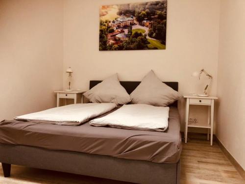 a bed in a room with two tables and a painting on the wall at Ferienwohnungen Mey Haus zum Rosenstock in Erfurt