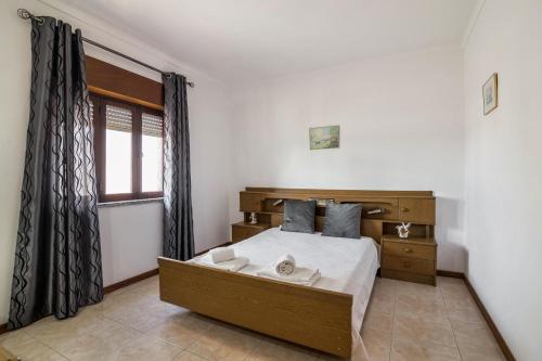 a bedroom with a large bed and a window at Casa Guerreiro in Branqueira