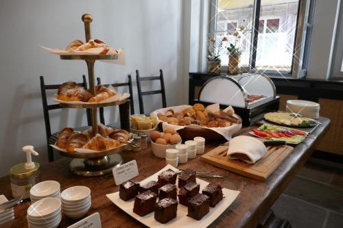 a table topped with different types of bread and pastries at Goldenstern Townhouse in Bolzano