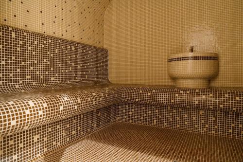 a tiled bathroom with a toilet in the corner at SPA Resort St Ivan Rilski - Halfboard & All Inclusive in Bansko