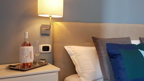 Una cama con una mesa con una botella de vino y una lámpara en Hotel Meublè Santa Chiara Suite, en Nápoles