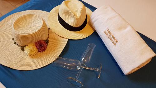 due cappelli di paglia e un paio di occhiali su un tavolo di Hotel Meublè Santa Chiara Suite a Napoli