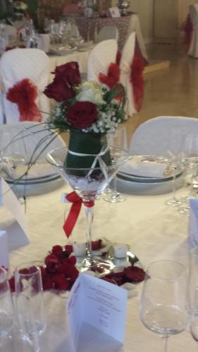 a table with a wine glass with flowers on it at Palazzo Del Papa Agriturismo in Strettura
