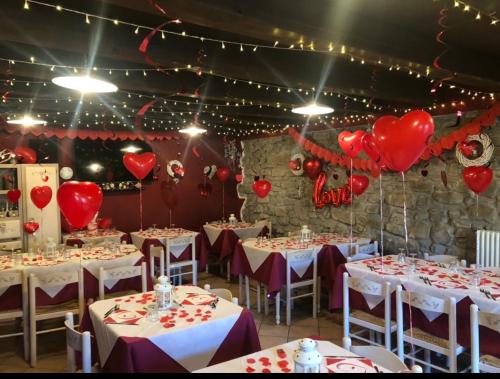 uma sala cheia de mesas com corações no tecto em Agriturismo Al Castagno em Abetone