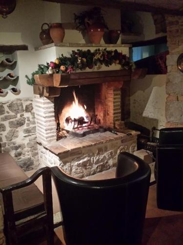 a brick fireplace with a fire in it at Palazzo Del Papa Agriturismo in Strettura