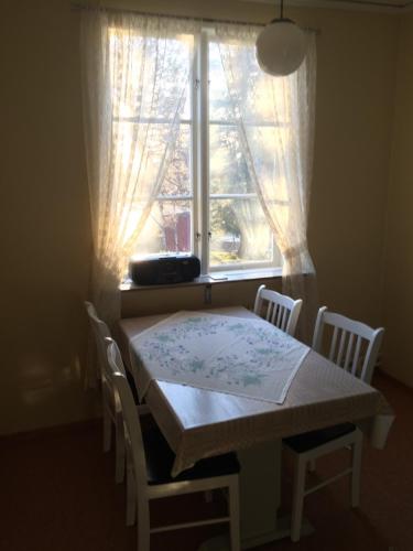 a table and chairs in front of a window at Å-hemmet i Dikanäs in Kittelfjäll
