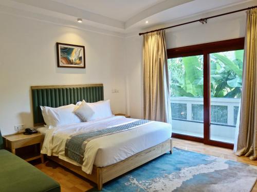 Zero Degree Residence في Fuvahmulah: غرفة نوم بسرير ونافذة كبيرة