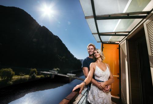 a man and a woman standing on the balcony of a train at Hotel Thermana Park Laško**** Superior in Laško