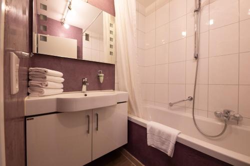 La salle de bains est pourvue d'un lavabo, d'une douche et d'une baignoire. dans l'établissement Alpennest, à Garmisch-Partenkirchen