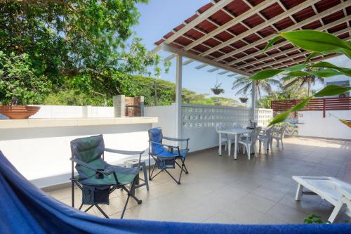a patio with chairs and a table and a fence at Ilha Azul House in Ponta do Ouro