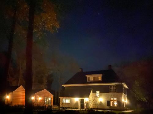 a large white house with lights on at night at Relais & Chateaux De Struyckenbergen - villa met wellness in Elspeet