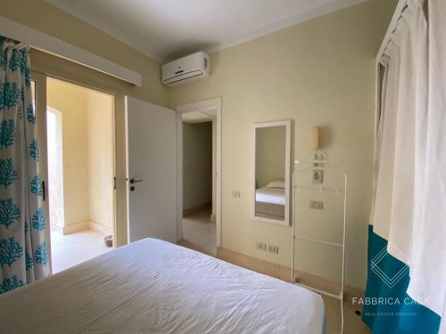 a bedroom with a white bed and a mirror at One bedroom Comfy Apartment by the sea, in Oriental Coast in Marsa Alam City