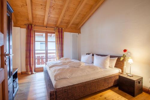 a bedroom with a large bed with a large window at Haus am Katzenbach in Garmisch-Partenkirchen