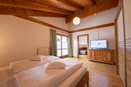 a bedroom with a bed and a flat screen tv at Alpen Chalet in Garmisch-Partenkirchen