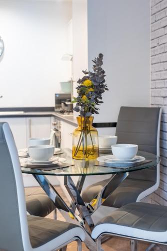 a glass table with two chairs and a vase with flowers at No11 Nursery Covent in Mansfield
