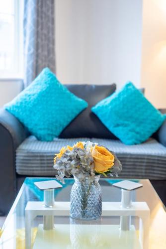 a vase with flowers on a glass table in a living room at No11 Nursery Covent in Mansfield