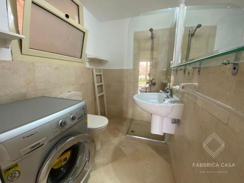 a bathroom with a washing machine and a sink at One bedroom Comfy Apartment by the sea, in Oriental Coast in Marsa Alam City