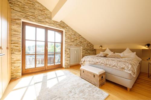 um quarto com uma cama e uma parede de tijolos em Dachgeschoss Wohnung Akelei am Fuße der Zugspitze em Grainau