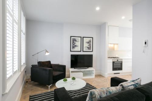 a living room with a couch and a table at Urban Chic - Shaftesbury in London