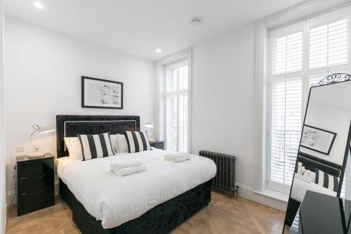 a bedroom with a large bed with two towels on it at Urban Chic - Shaftesbury in London