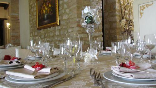 a table with wine glasses and napkins on it at Palazzo Del Papa Agriturismo in Strettura